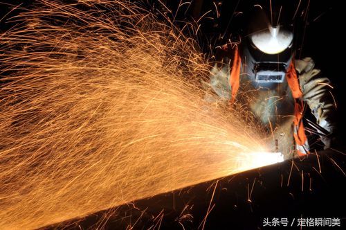 图为:重工企业里,一名电焊工人焊接作业中.